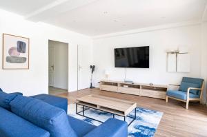 昂蒂布Villa Constance - Antibes的客厅配有蓝色的沙发和电视