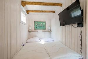 卡兰茨奥赫In Ons Tuintje - aan zee - Callantsoog的小房间设有床铺和电视
