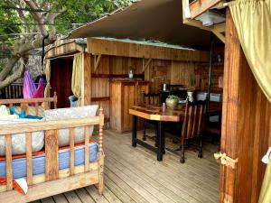 开普敦Scarborough Nature Lodge的木甲板,配有桌子和饭厅