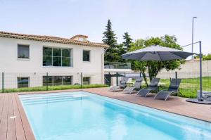 昂蒂布Villa Constance - Antibes的房屋旁的游泳池配有椅子和遮阳伞