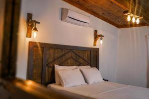 切什梅Belong Butik Otel的一间卧室配有一张带木制床头板和灯的床。