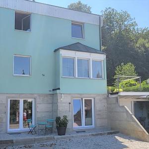 克罗伊茨林根Charmante Waldrandidylle的蓝色的房子,设有窗户和庭院