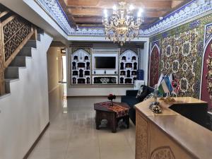 布哈拉Antique hotel Imran的客厅配有吊灯和波斯瓷砖