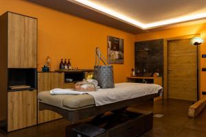 索拉加Wellness Hotel Dolomia的卧室配有一张床铺,位于一个黄色墙壁的房间