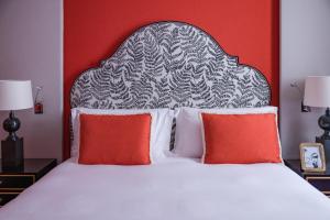 罗马Maalot Roma - Small Luxury Hotels of the World的一张带两个红色枕头的床和黑白床头板