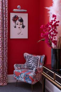 罗马Maalot Roma - Small Luxury Hotels of the World的红色的客厅,配有椅子和花瓶