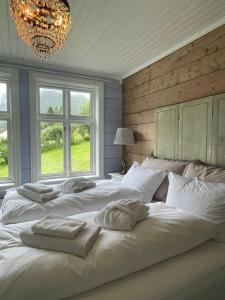 SykkylvenMonshaugen Home的卧室设有2张大型白色床和窗户。