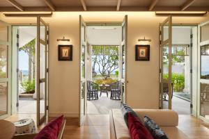 华欣Charras Bhawan Hotel and Residences的客厅设有滑动玻璃门,可通往庭院