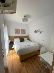 Habitación intima con patio privado的白色卧室配有床和桌子
