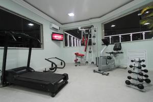 桑托斯Gonzaga Flat的一间设有跑步机和举重器材的健身房的客房