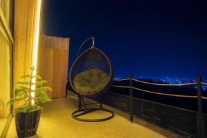 艾卜哈Terhabb Cottages的秋千椅,晚上坐在阳台上