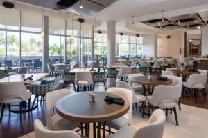 迈阿密迈阿密机场原住客栈酒店的餐厅设有桌椅和窗户。