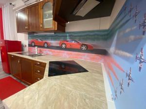 BrusimpianoIl Cavallino, sul lago Ceresio的厨房墙上挂着一幅红色汽车的画作