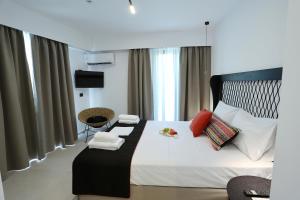 斯卡拉雅娜酒店的一间卧室配有一张大床,配有白色床单和红色枕头