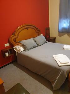 拉瓦克拉A Concha的一间卧室配有一张大床和木制床头板