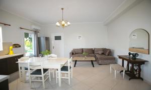 里科索翁BABI'S VILLA - Garden apartment的厨房以及带桌子和沙发的客厅。