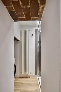 锡耶纳Casa Monelli的走廊设有白色墙壁和窗户天花板