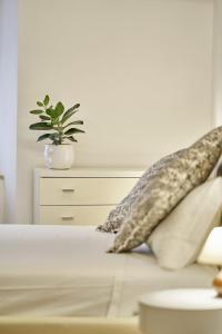 锡耶纳Casa Monelli的床上有枕头,上面有盆栽植物