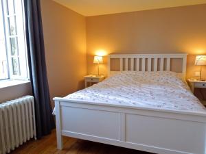 Le FaouëtLe grenier du Faouët的一间卧室配有白色床和2个床头柜