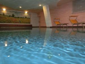 卡拉诺玛丽亚美丽生命酒店的大楼内一个带两把椅子的游泳池
