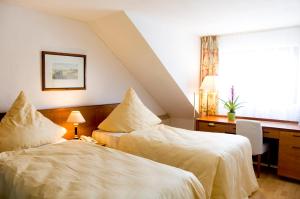 贝尔吉施格拉德巴赫瑞法拉舍科隆酒店的一间卧室设有两张床、一张桌子和一个窗口。