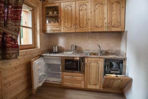 摩德纳迪-坎皮格里奥Chalet Camping Faè 2的一个带木制橱柜和水槽的小厨房
