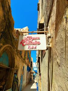 索维拉Les Terrasses d'Essaouira的建筑物一侧有标志的小巷