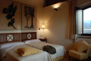 ArbizuOLATZEA LANDA HOTELA的酒店客房设有两张床和窗户。