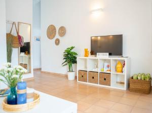 休达德亚Casa Menorquina centro Ciutadella的一间客厅,在白色架子上配有电视