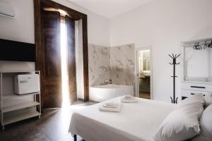 那不勒斯La bella vita luxury apartament and travel solution的一间白色卧室,配有浴缸和一张床