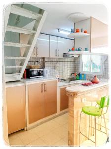 西迪·布·赛义德Cosy Duplex" Sidi Bou Said "的厨房配有棕色橱柜和绿色凳子