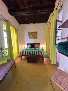 索维拉Les Terrasses d'Essaouira的一间设有床铺的卧室,位于带绿色窗帘的房间