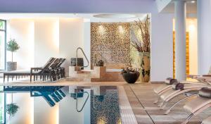萨尔巴赫诺伊豪斯酒店的配有桌椅和游泳池的客房