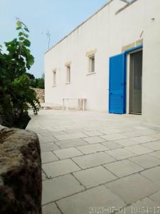 莫尔恰诺迪莱乌卡Domus Veretum的白色的建筑,设有蓝色的门和庭院