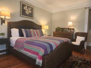 小石城Rosemont B&B Cottages的一间卧室配有一张带毯子和椅子的床