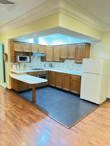 阿可贺巴宫殿酒店的厨房配有木制橱柜和白色冰箱。