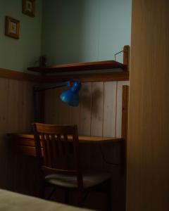 惠拉盖尔济Backyard Village的客房配有一张带蓝灯和椅子的书桌