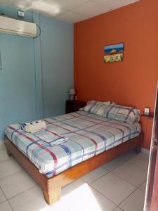 博卡斯德尔托罗Surfari Bocas的一间卧室配有一张橙色墙壁的床