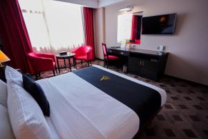 麦纳麦Arman Hotel Juffair Mall的酒店客房,配有一张床、一张桌子和椅子