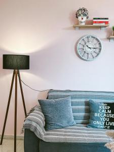 依拉佩特拉SeaSideRooms的客厅配有沙发和墙上的时钟