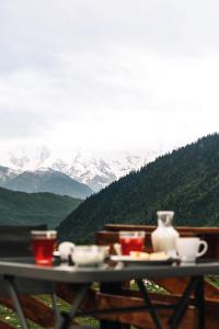 梅斯蒂亚Panorama Ushba的山顶上带食物和饮料的桌子