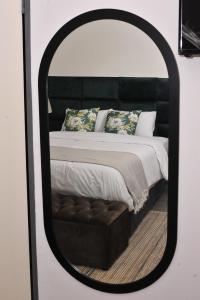 哈博罗内Square Connexions Guest House的一间带镜子内床的卧室