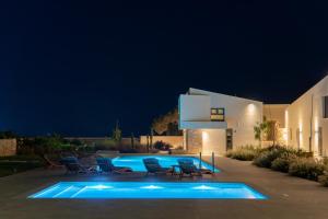 锡蒂亚Itida Suites的夜间在房子前面的游泳池