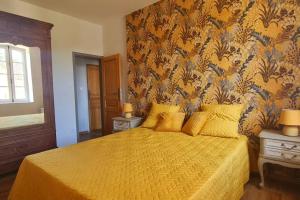VilledubertDomaine VILLECARLA的一间卧室配有一张黄色床罩的床