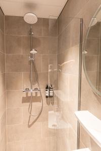 赞丹Distrikt Hotels Amsterdam Zaandam的浴室里设有玻璃门淋浴