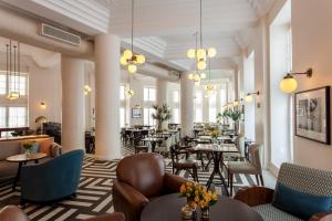 萨尔瓦多Fera Palace Hotel的一个带桌椅的大堂和一间餐厅