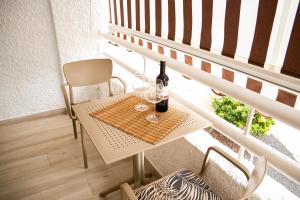 美洲海滩Luxury Suite Borinquen的阳台上的桌子上放着两杯酒和一瓶葡萄酒