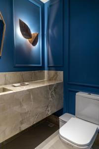 佩德拉阿祖尔Pousada e Cerimonial Itamaraty的一间带卫生间和蓝色墙壁的浴室