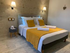 图尔农－圣马丹Hotel The Originals Le Manoir de Pierre Levée的一间卧室配有一张带黄色枕头的大床