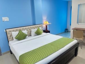 商沙巴Classic Hotel的一间卧室配有一张带绿色枕头的大床
